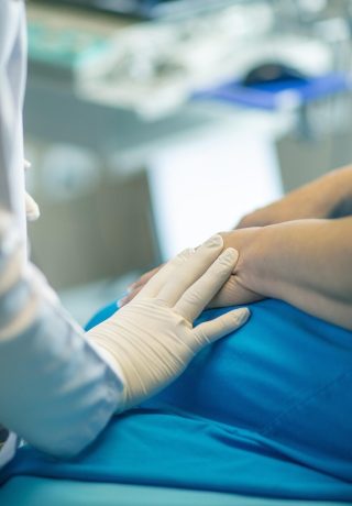 surgeon placing a comforting hand on a patient